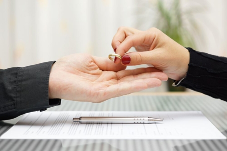 exchanging wedding ring while signing paper